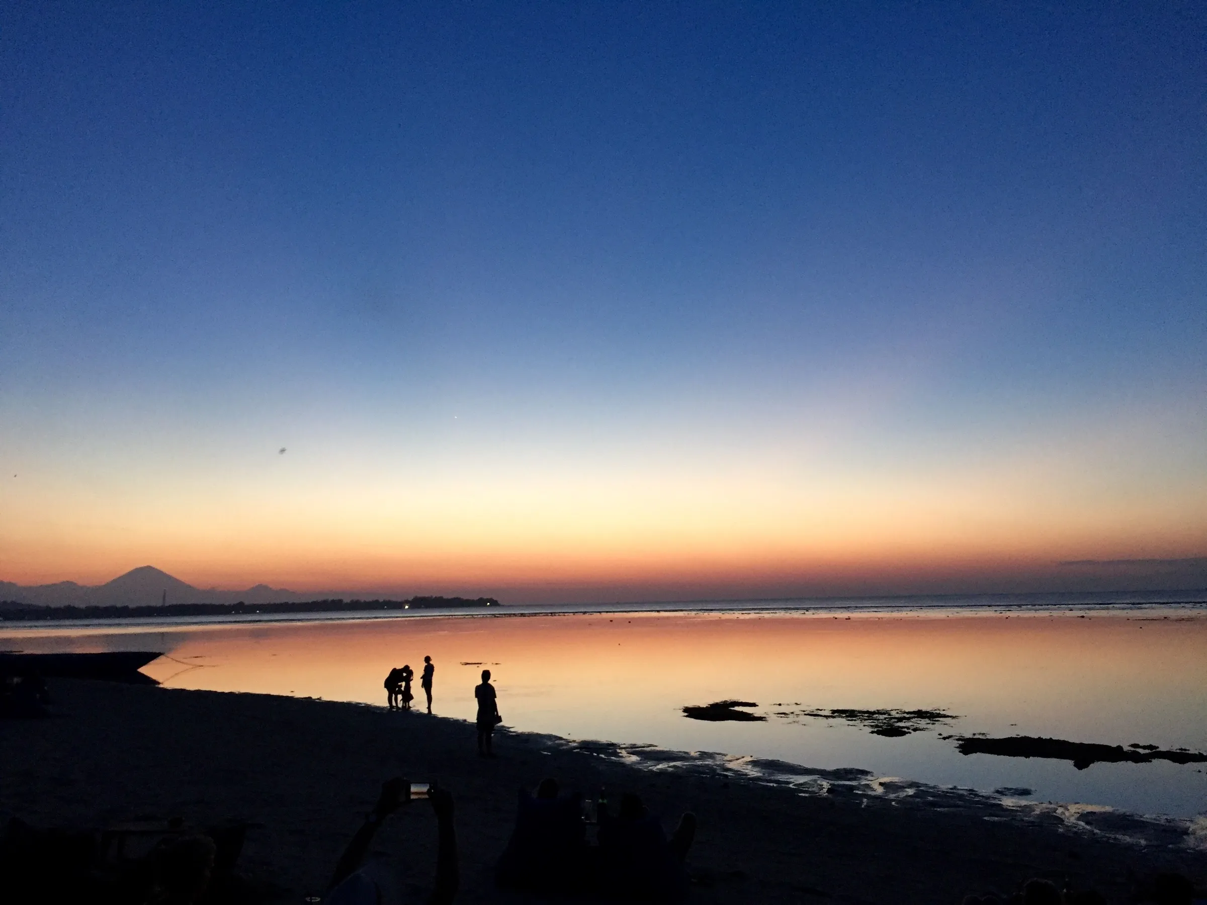 Beachgoers at sunset