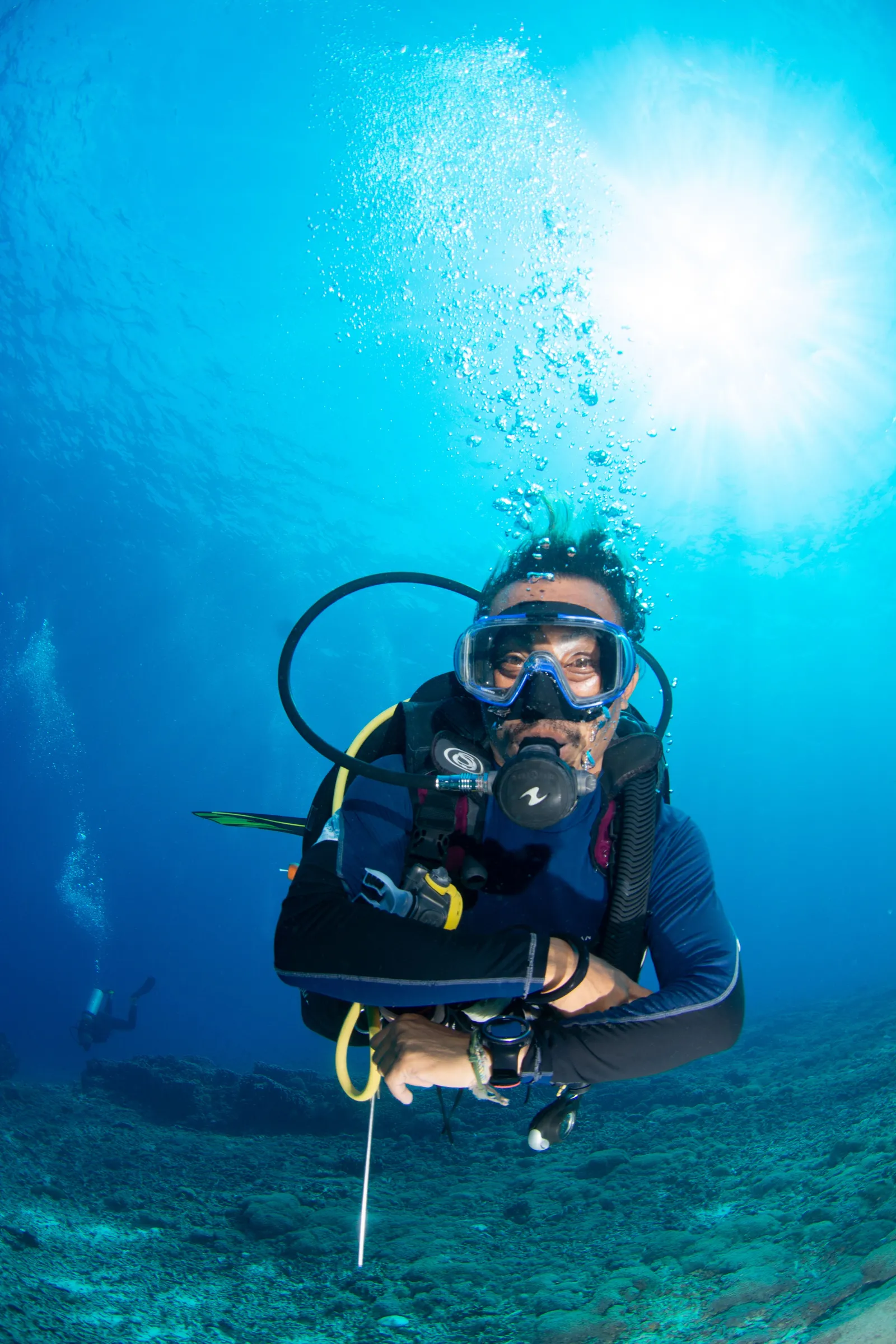 Diver hovering with sunburst above