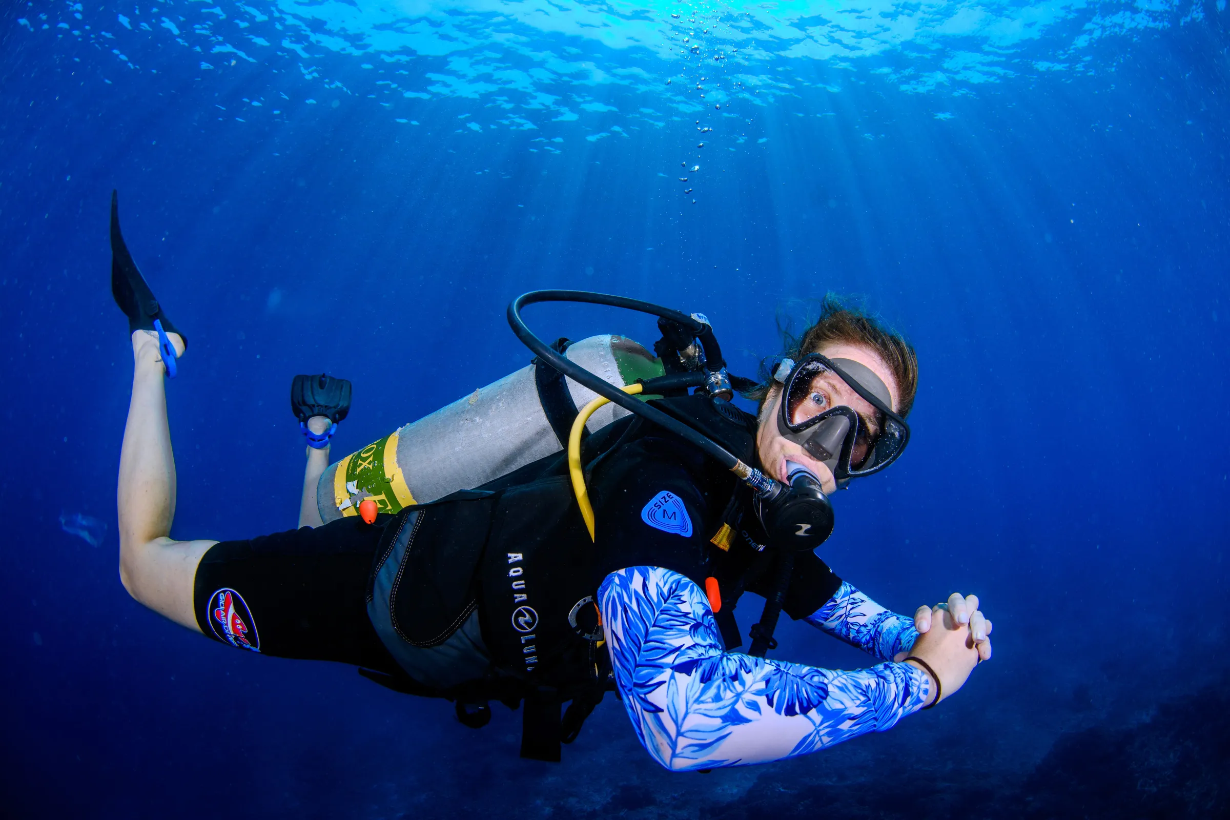 Diver giving OK sign in blue