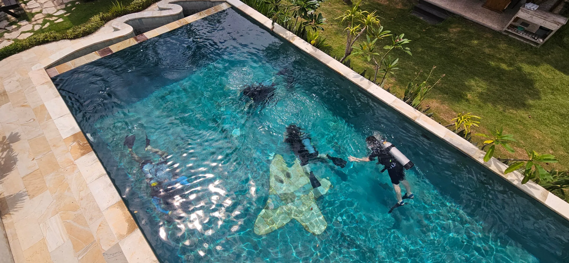 Diver kneeling underwater in pool