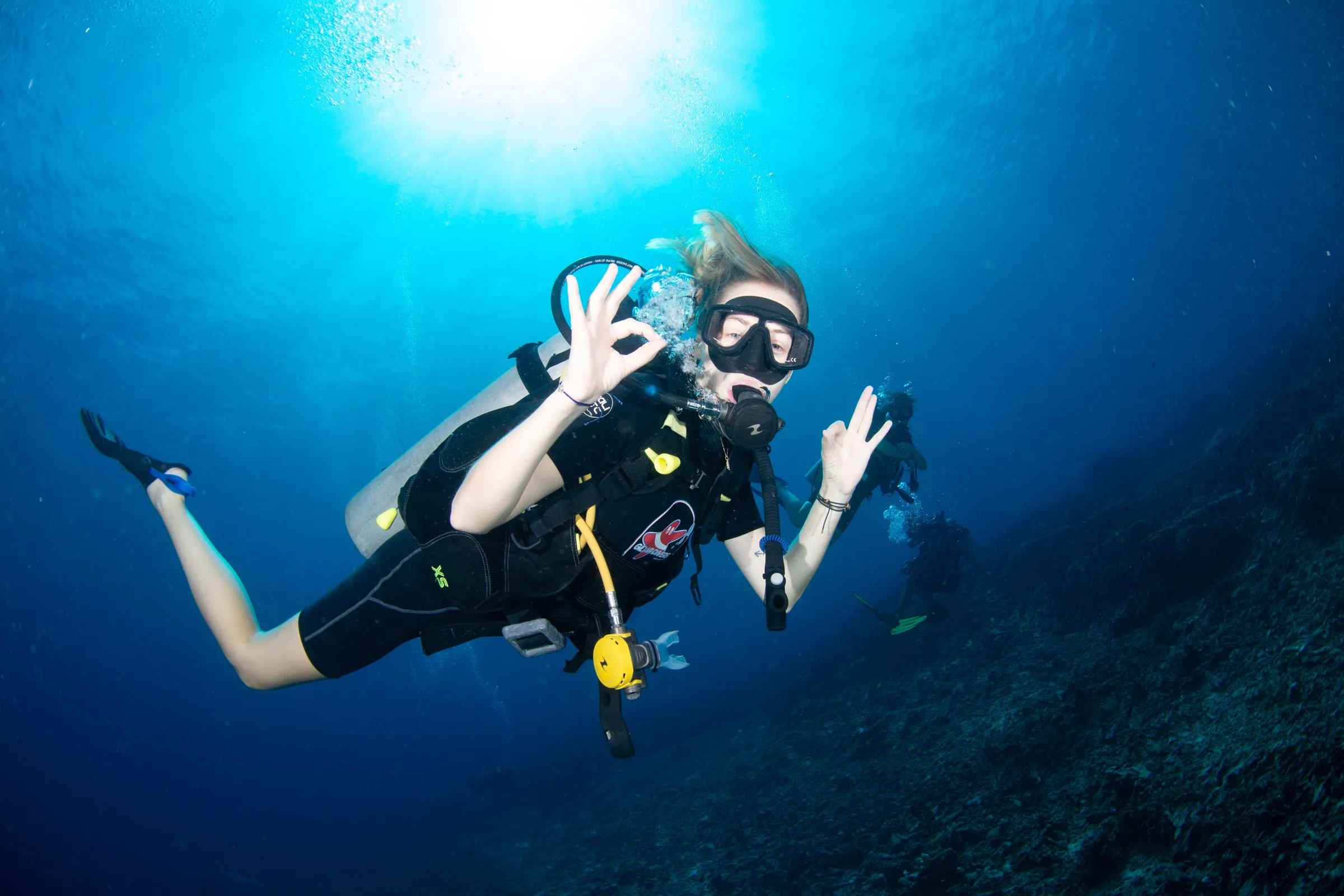 Diver giving OK with sunburst